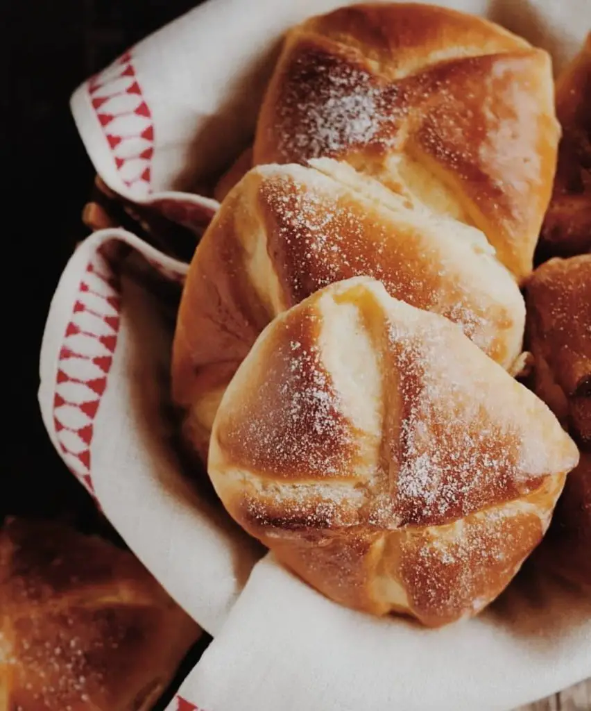 Cheese pastries, a traditional Romanian dessert, on a red and white napkin in a basket.