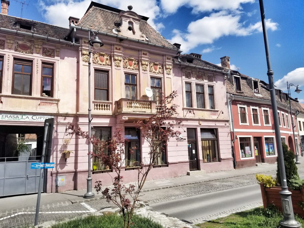 Beautiful pink façade of La Cuptor, an excellent date night restaurant in Sibiu, Romania. 