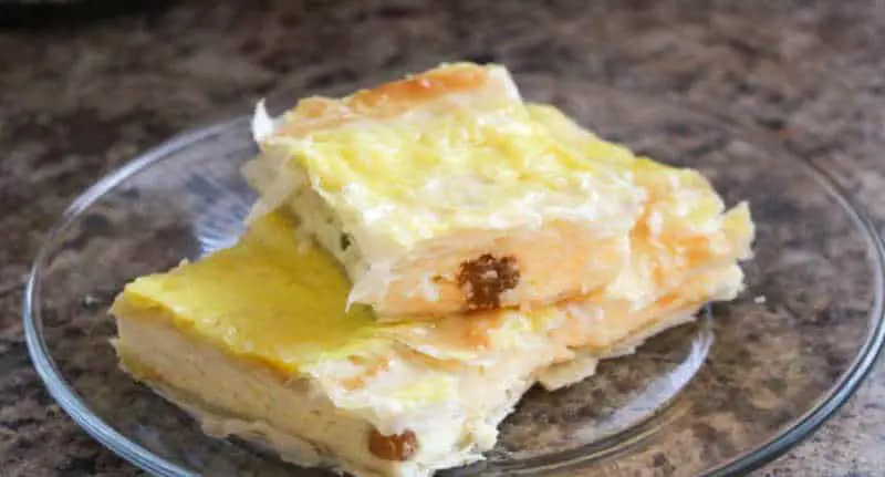A few squares of cheese pie on a crystal plate, a traditional Romanian dessert.