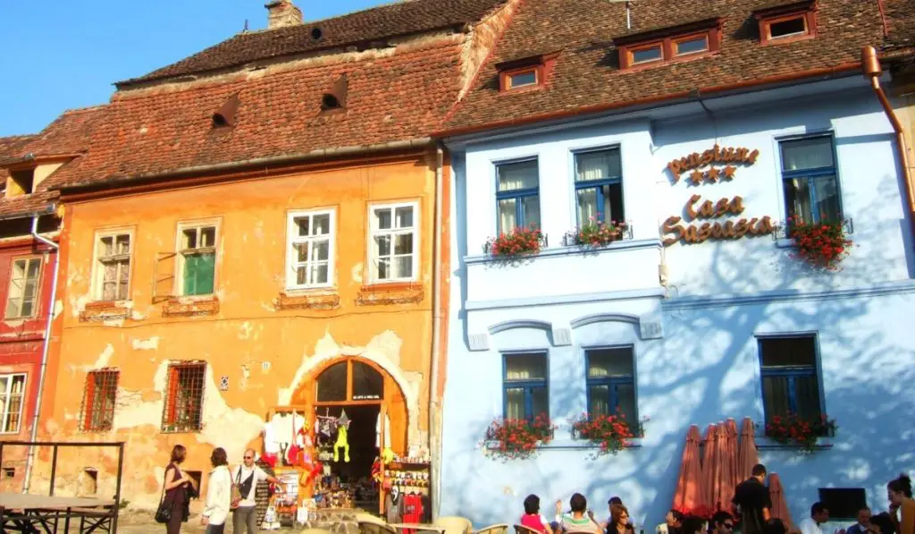 Colorful orange and blue storefronts in Sighisoara, Transylvania, Romania.