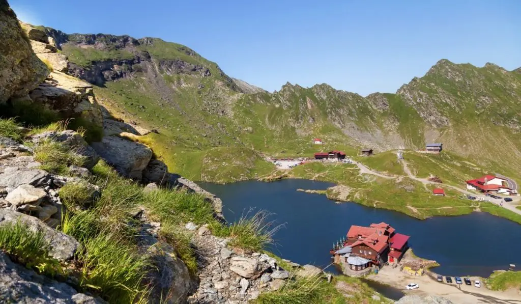 Balea Lake seen from above with a red lakeside cabin in foreground.