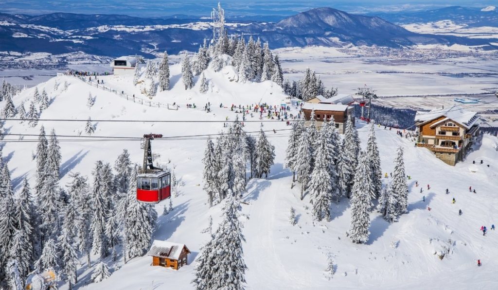 Snow covered slopes with red ski lifts in Poiana, Transylvania, Romania.