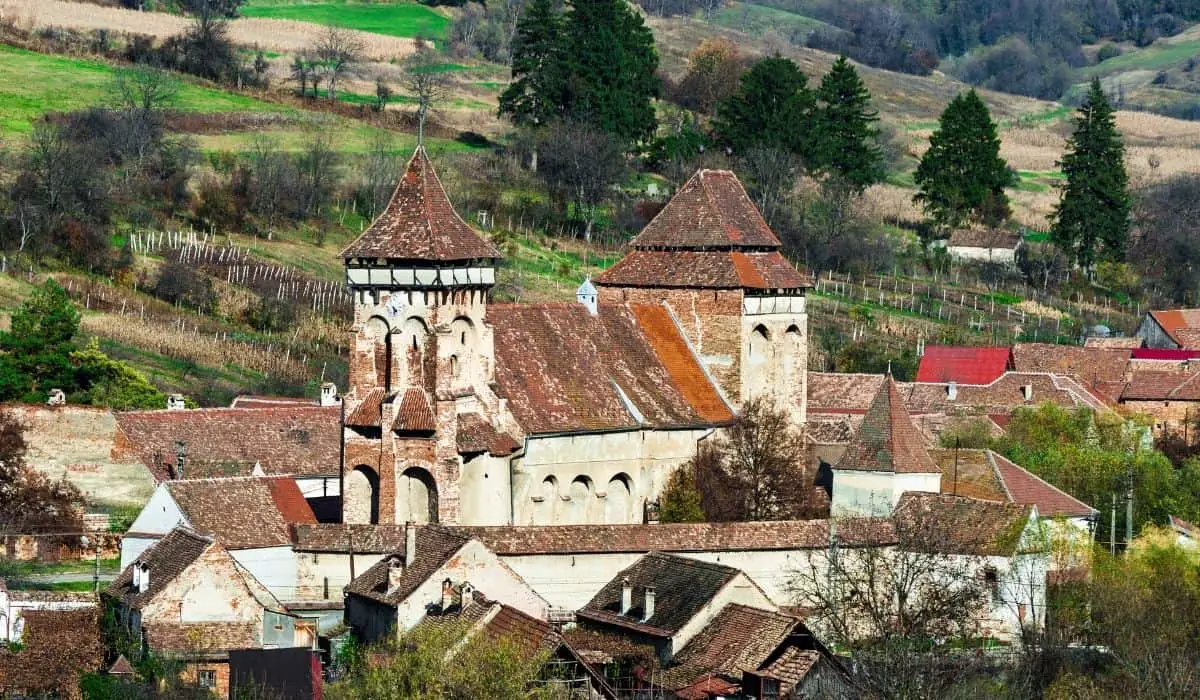 Fortified church of Valea Viilor with rustic farmlands in the background.