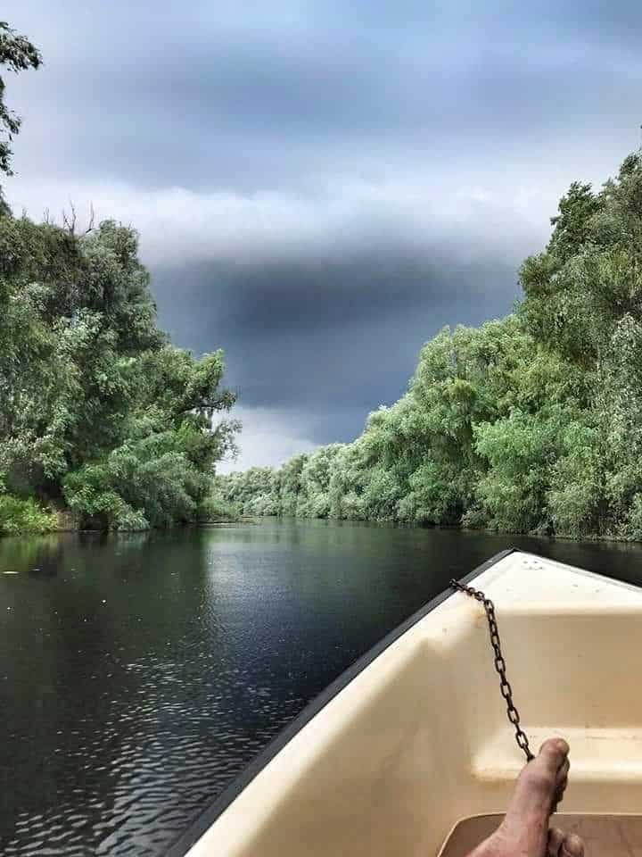 Storm clouds and front of boat on Danube River, Romania