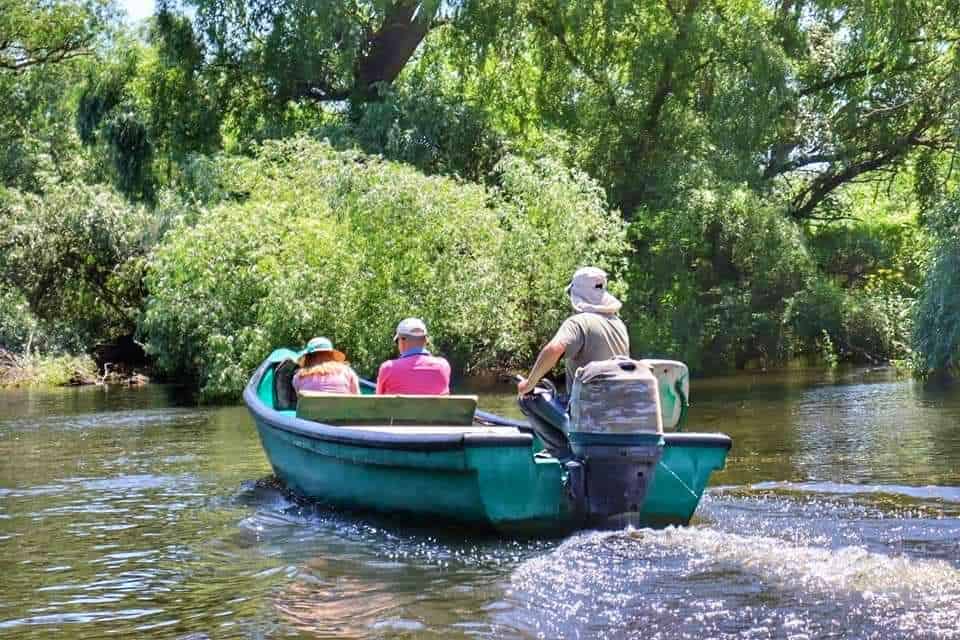 Group of people in a green boat on the Danube Delta, Romania
