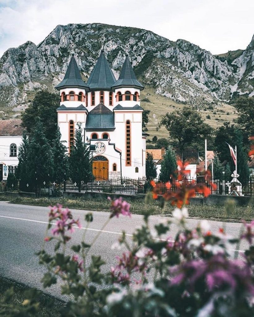 Beautiful church in front of rocky mountains in Rimetea, Romania.