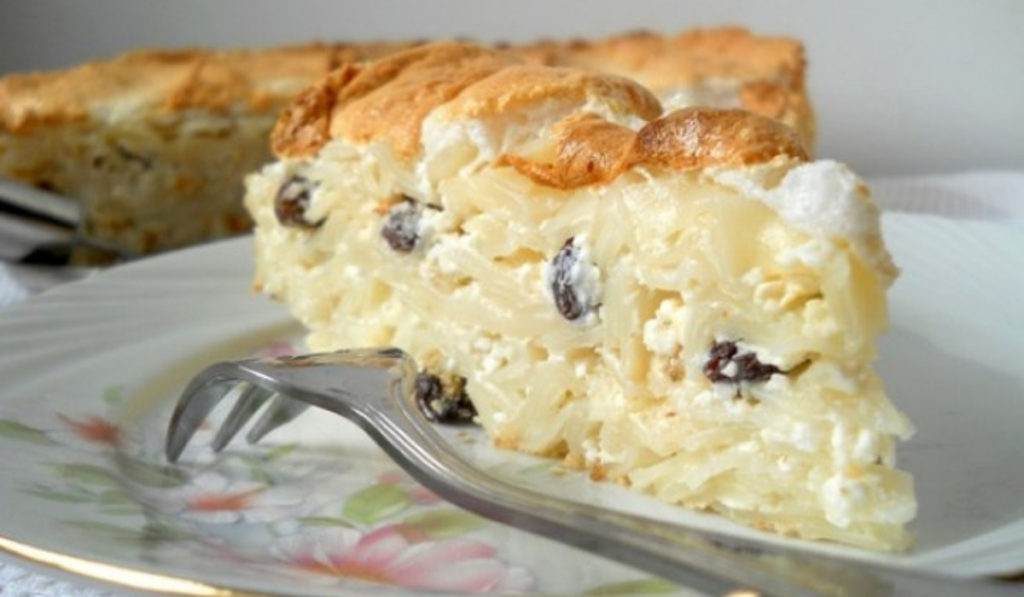 Transylvanian noodle pie with raisins and a fork, a traditional Romanian dessert.