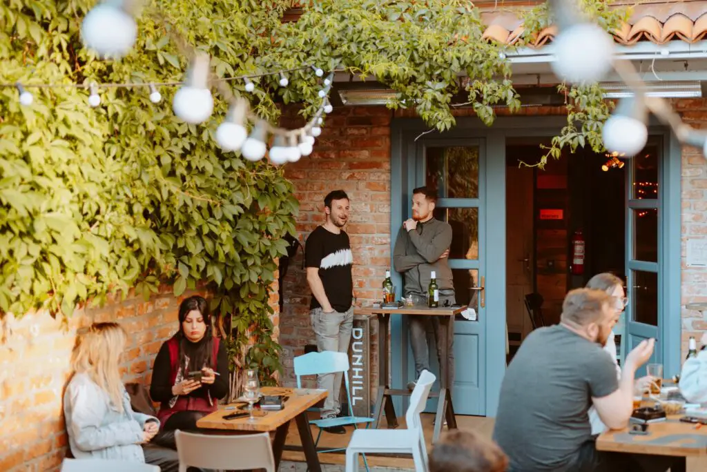 Outdoor patio with groups of people enjoying drinks in Cluj-Napoca.