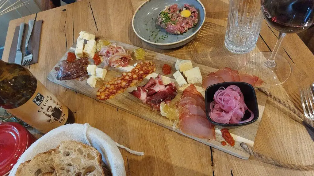 Charcuterie plate and beef tartare on a set table in Cluj-Napoca..