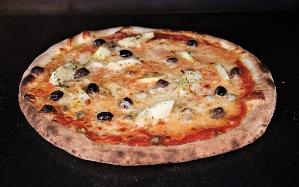 Cheesy pizza with artichokes and olives in Cluj-Napoca.