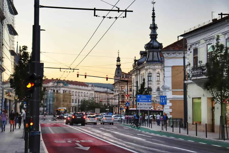 Cluj street at sunset with cars at a red light.