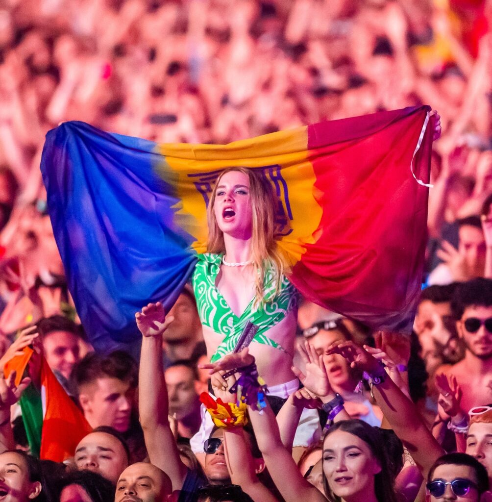 Woman at festival holding Romanian flag.