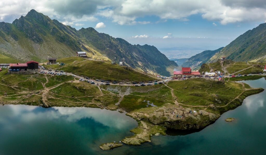 Panoramic view of Balea Lake dotted with red houses.