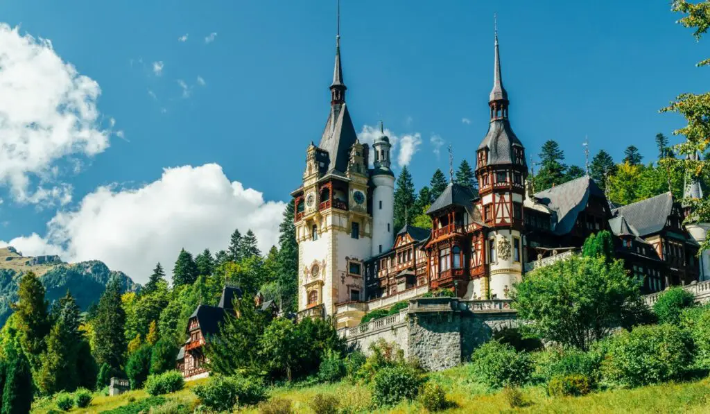 Beautiful Peles Castle amid lush greenery in Romania.